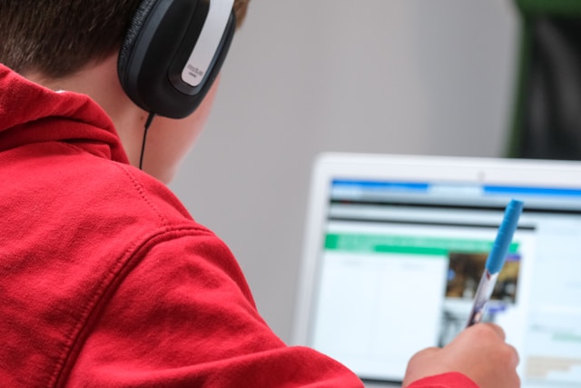 A student in headphones reading on a screen